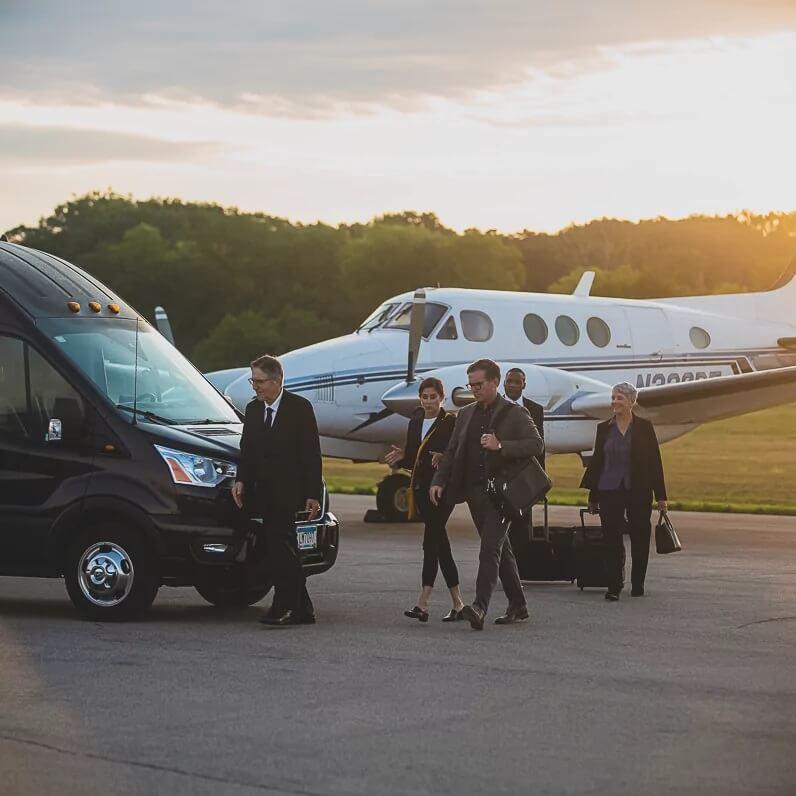 Executive group heading from plane to premium transport bus